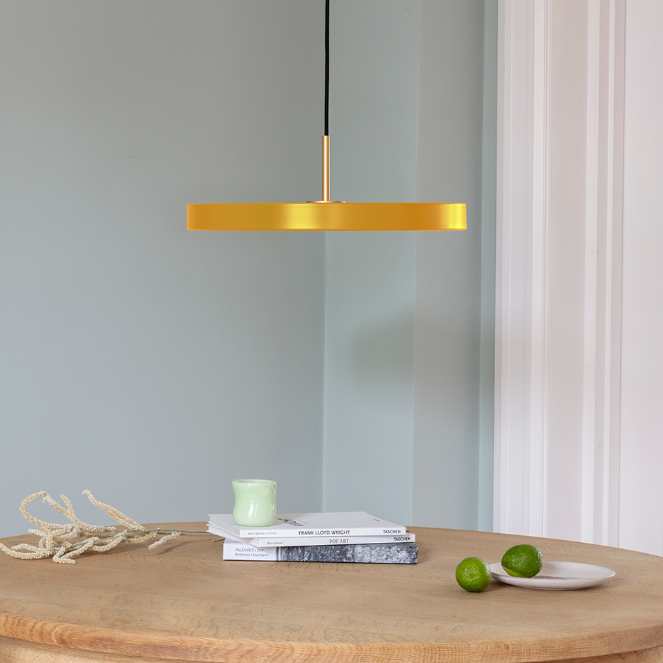 UMAGE Asteria LED Pendant in Saffron Yellow with Brass Connector — styled interior view