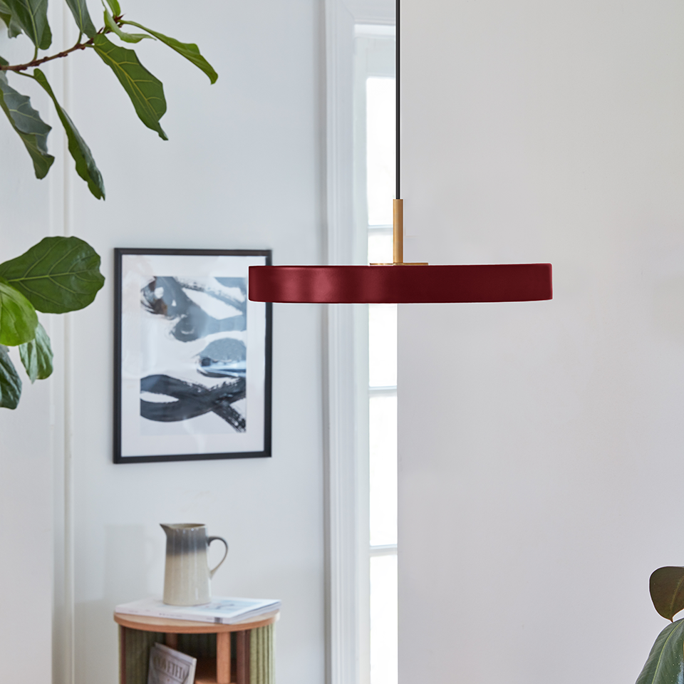 UMAGE Asteria Mini LED Pendant in Ruby Red with Brass Connector — styled interior view