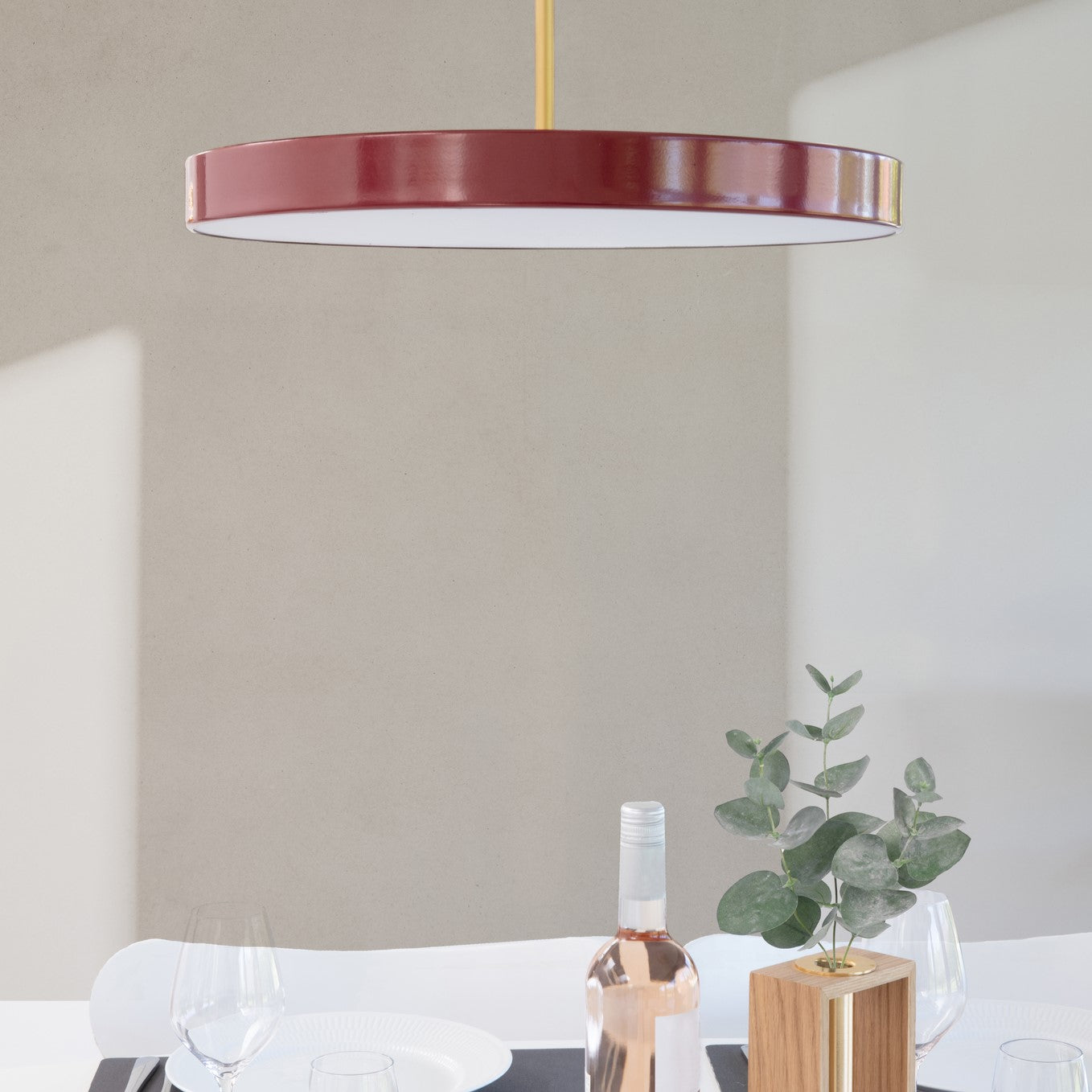 UMAGE Asteria LED Pendant in Ruby Red with Brass Connector — styled interior view 2
