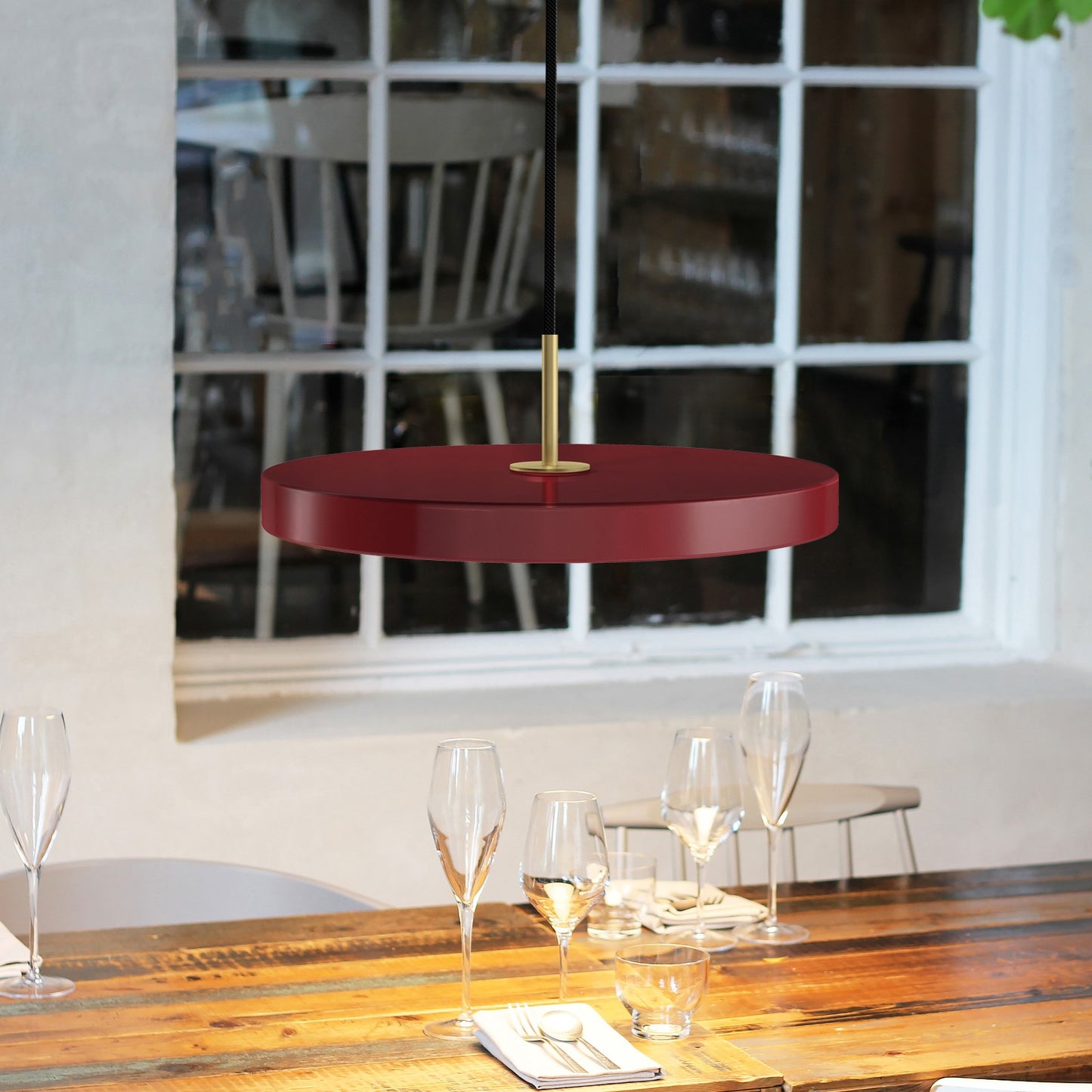 UMAGE Asteria LED Pendant in Ruby Red with Brass Connector — styled interior view