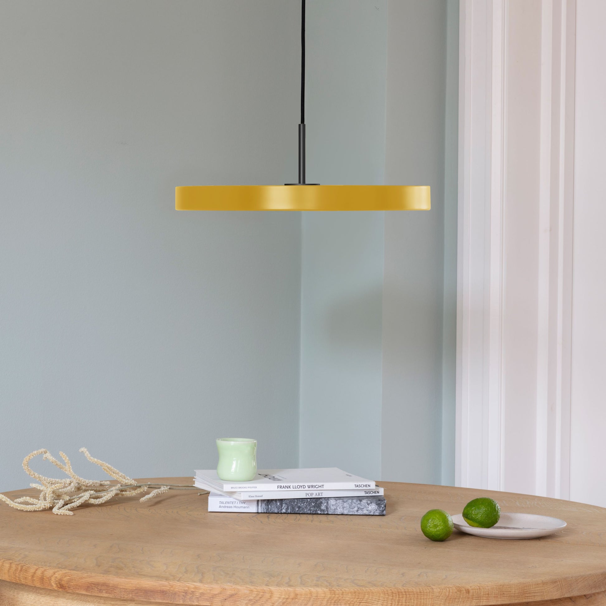 UMAGE Asteria LED Pendant in Saffron Yellow with Black Connector — styled interior view