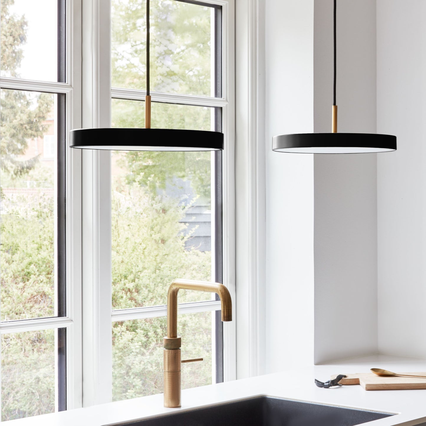 UMAGE Asteria Mini LED Pendant in Black with Brass Connector — styled interior view 3