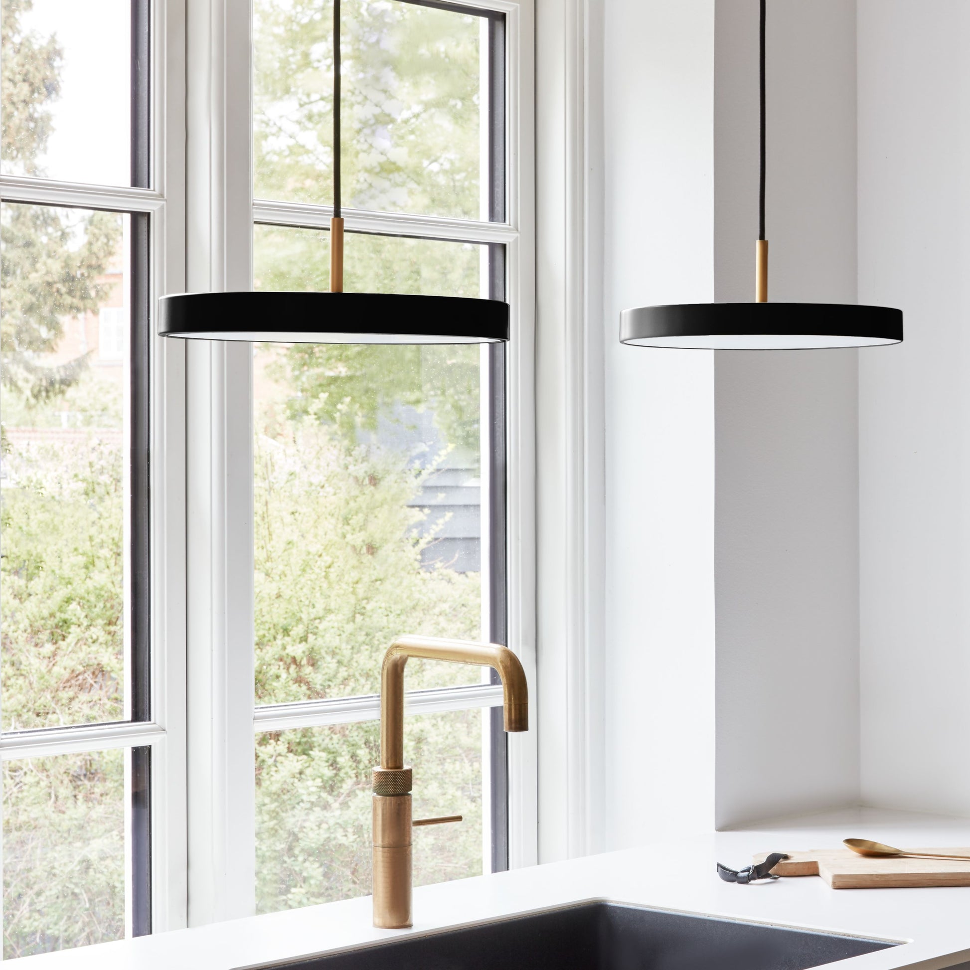 UMAGE Asteria Mini LED Pendant in Black with Brass Connector — styled interior view 3