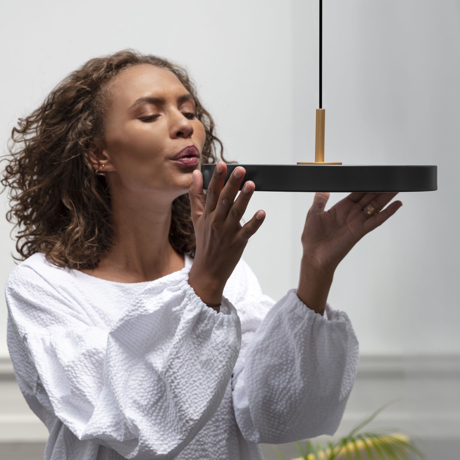 UMAGE Asteria Mini LED Pendant in Black with Brass Connector — styled interior view 2