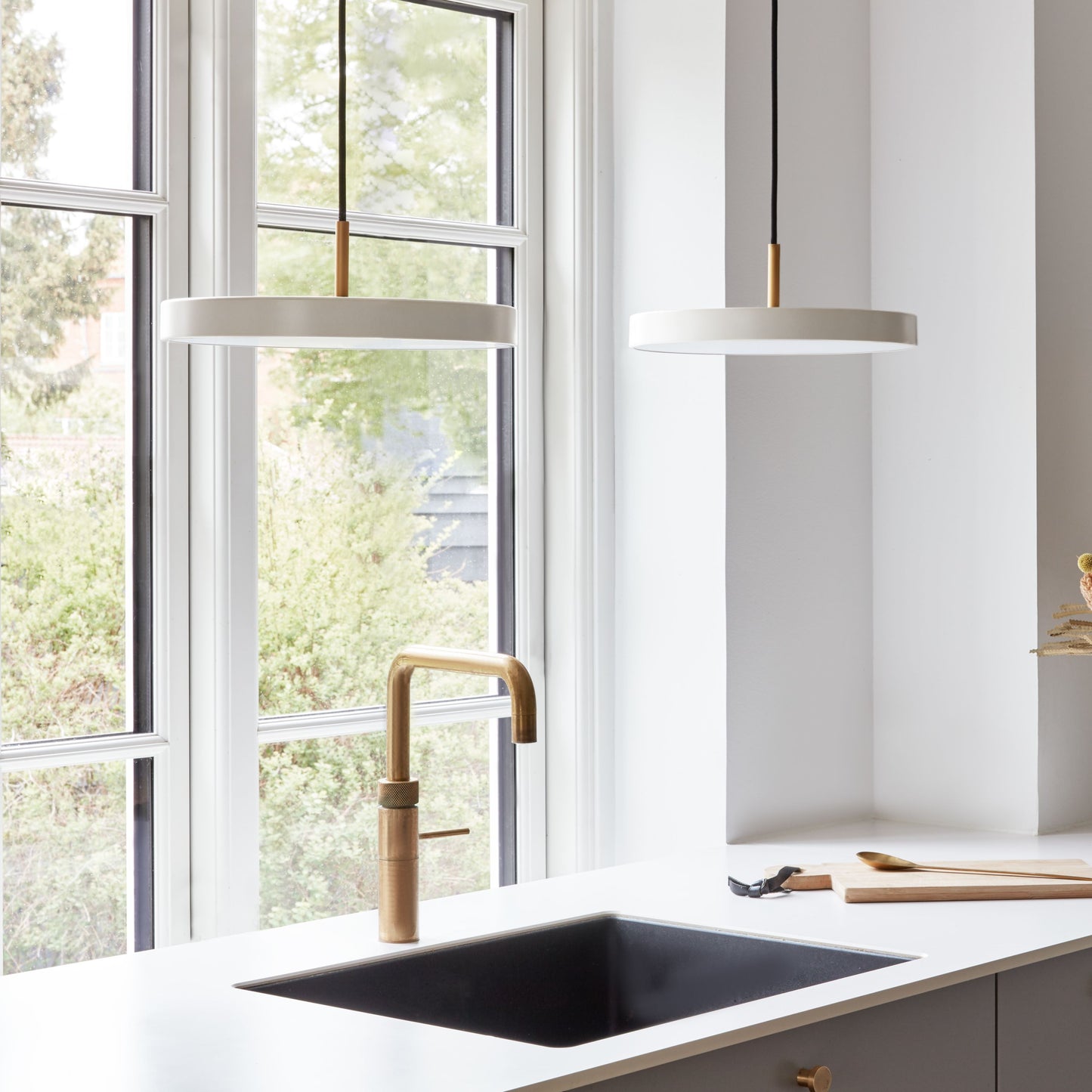 UMAGE Asteria Mini LED Pendant in Pearl White with Brass Connector — styled interior view
