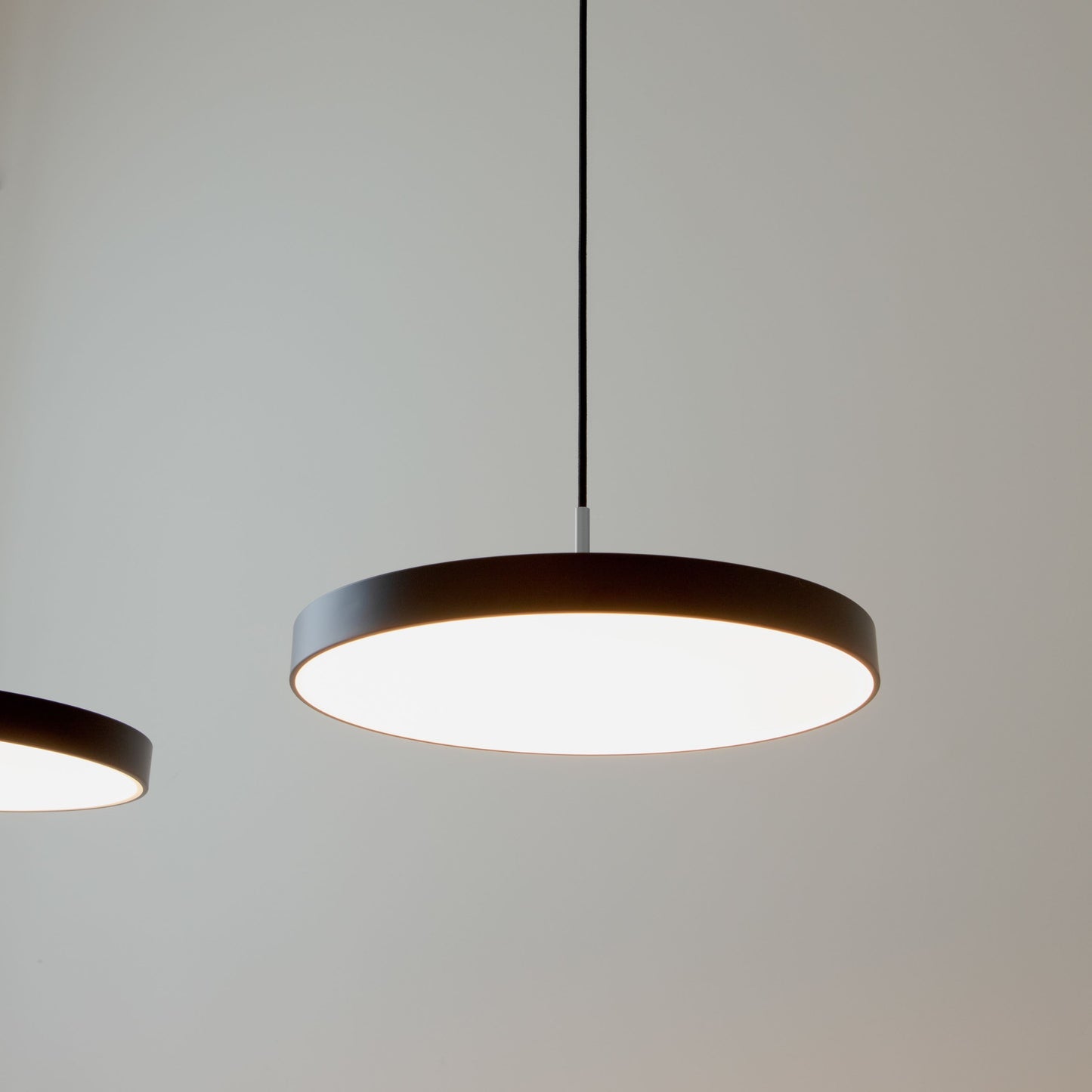 UMAGE Asteria LED Pendant in Black with Steel Connector — styled interior view 3