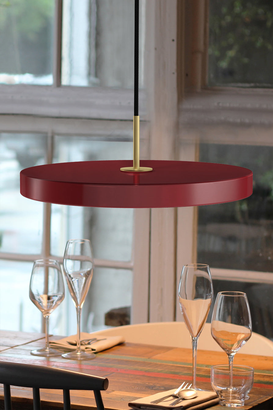 UMAGE Asteria LED Pendant in Ruby Red with Brass Connector — styled interior view 4